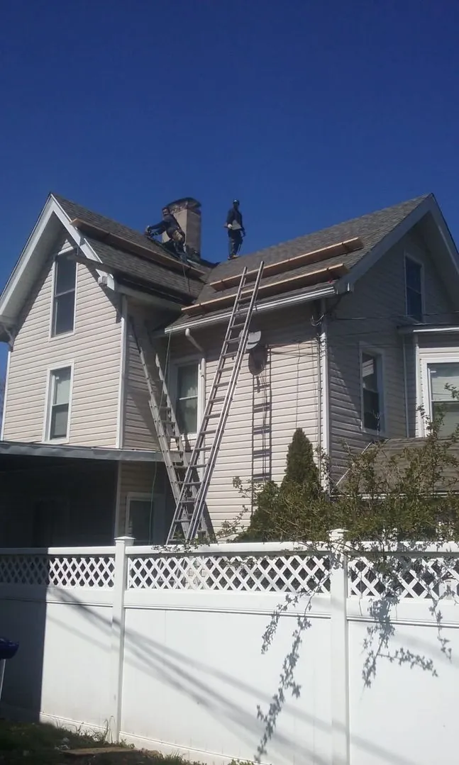 Two Leo and Company roofers at work on a gable roof