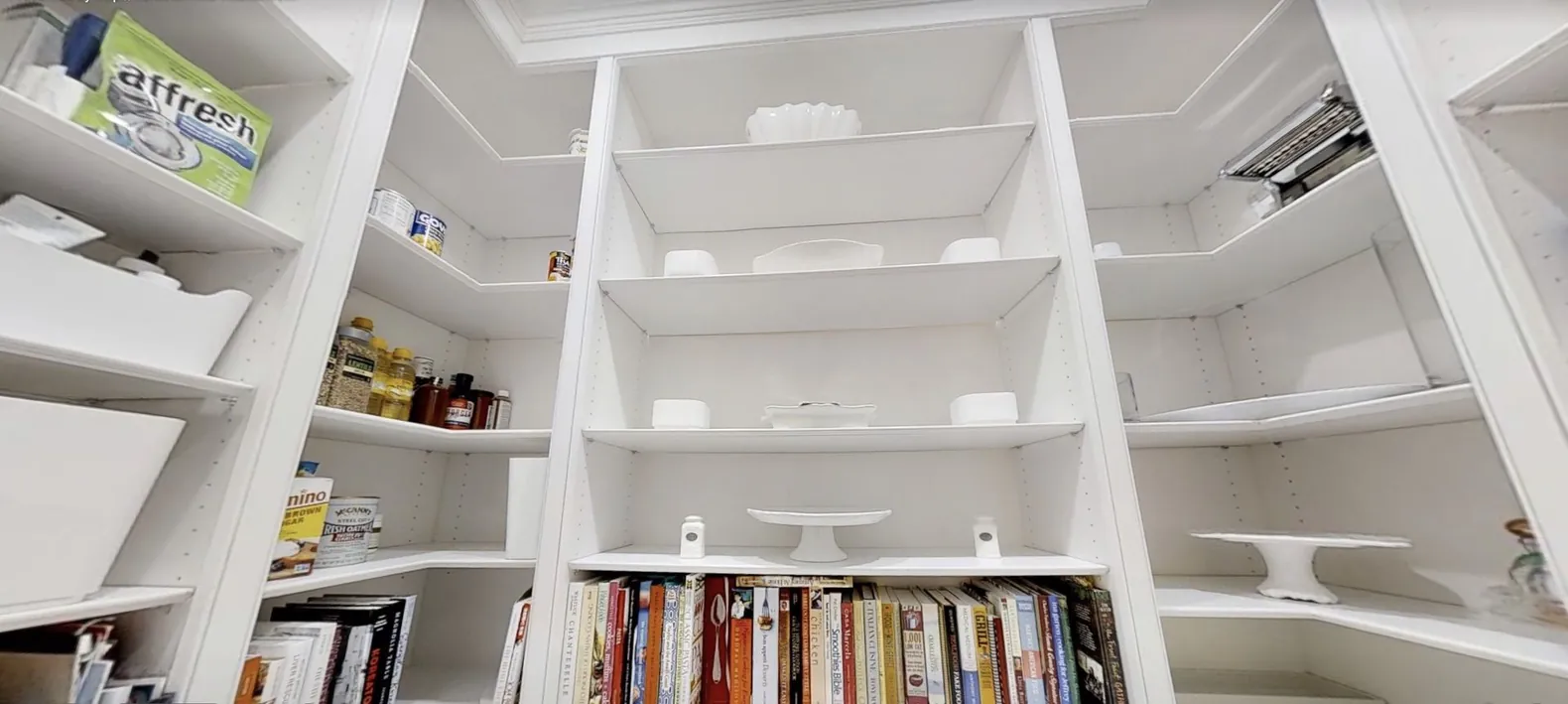 Built-in white library shelving filled with books