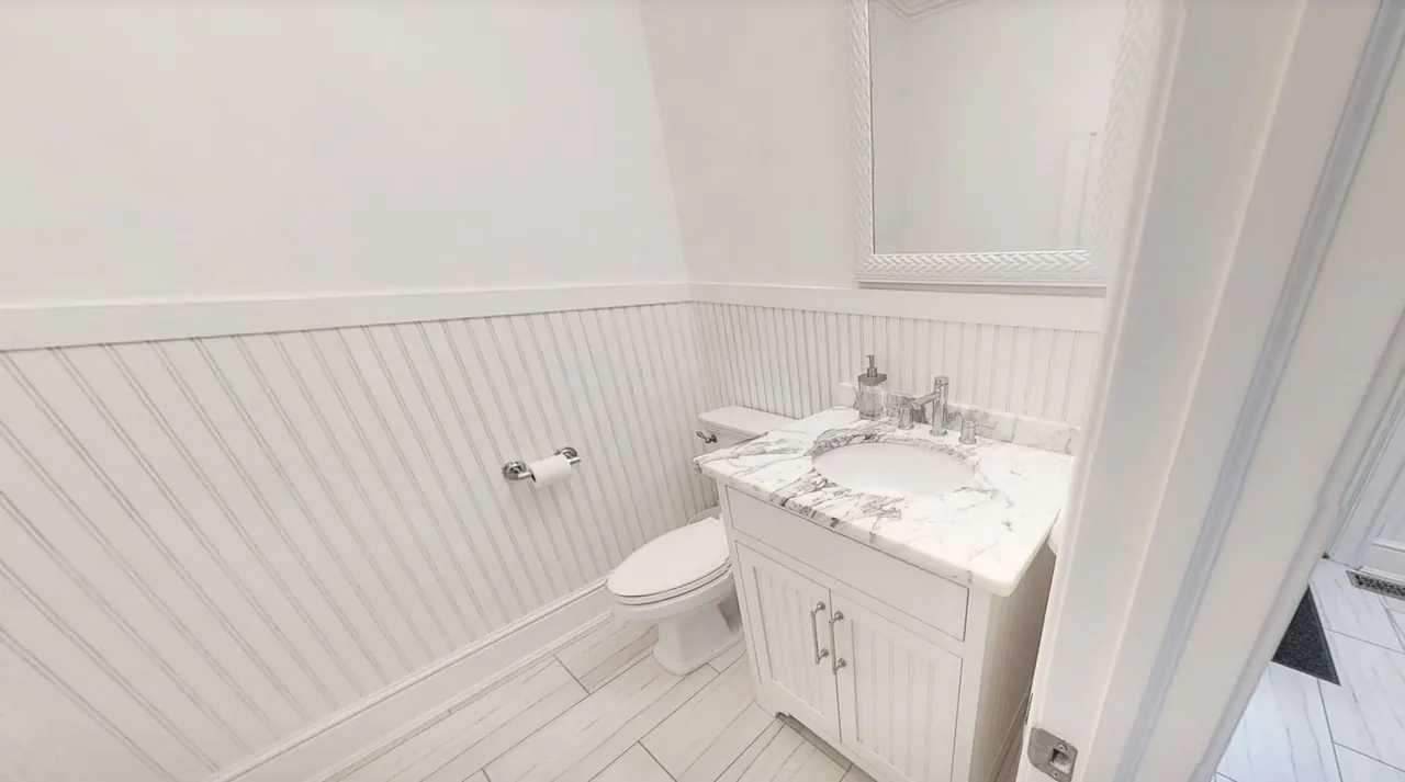 Guest bathroom with beadboard panelling and a white vanity