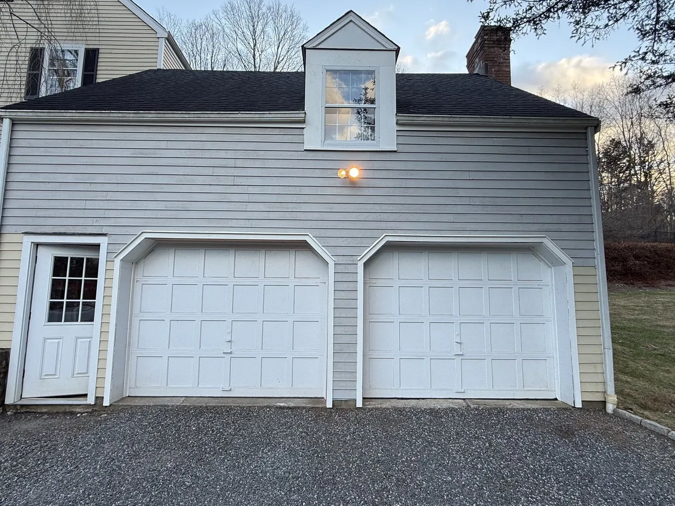 Detached two-car garage addition with a shed dormer and matching clapboard siding
