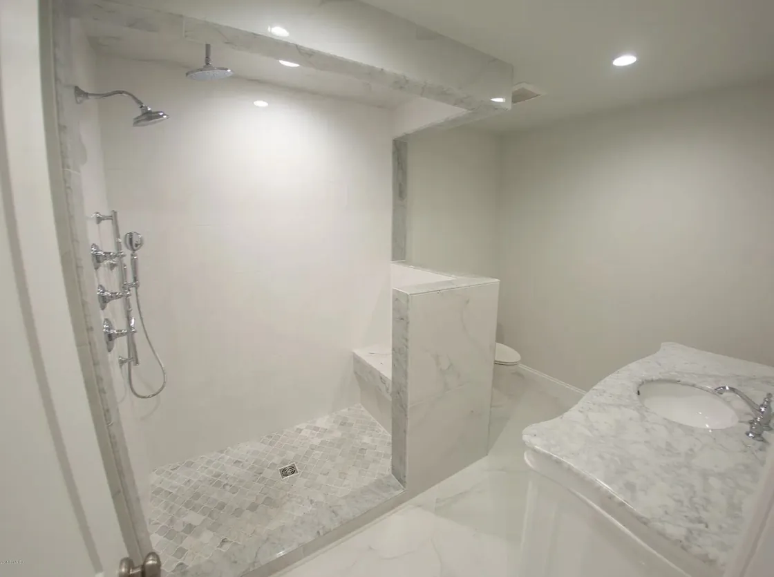 Curbless marble shower and soaking tub in a finished bathroom