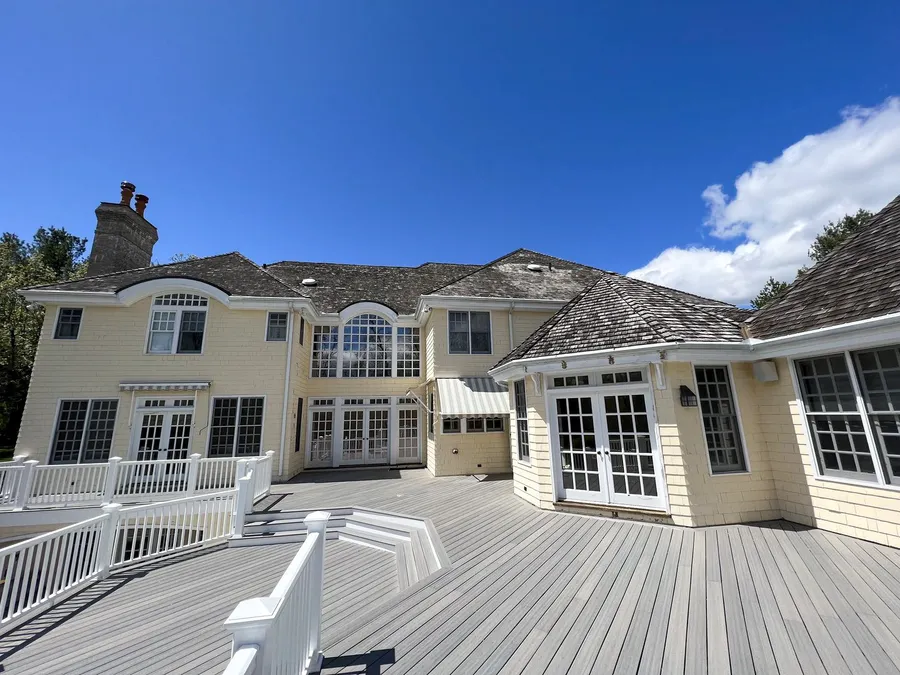 Rear elevation of a remodelled house with new siding and a wraparound deck